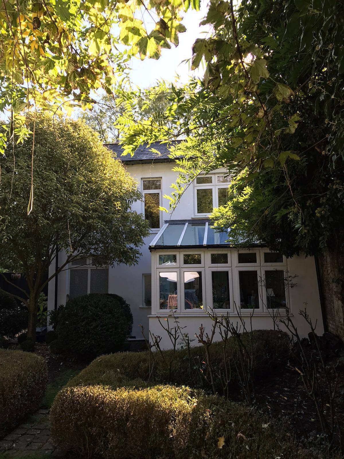Rear of the cottage before works, showing the conservatory the extension replaces (Design and Access Statement)