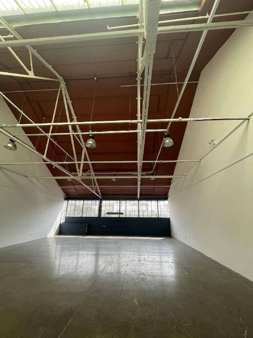The vacant double-height interior of the unit before conversion (Site photographs)