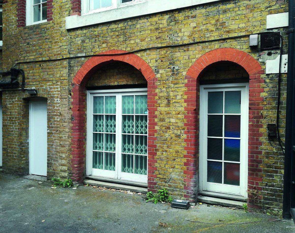 The existing rear elevation of the building at ground floor, with arched openings (Design and Access Statement site photographs)
